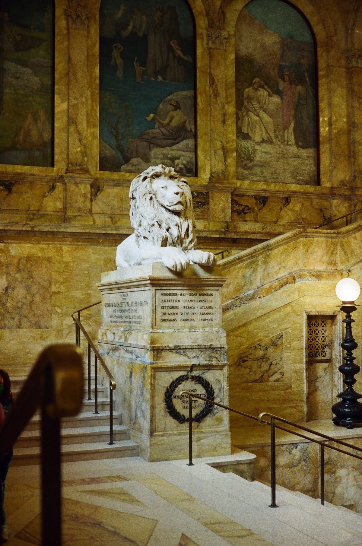 estatua de un león en la gran escalera de la biblioteca pública de Boston