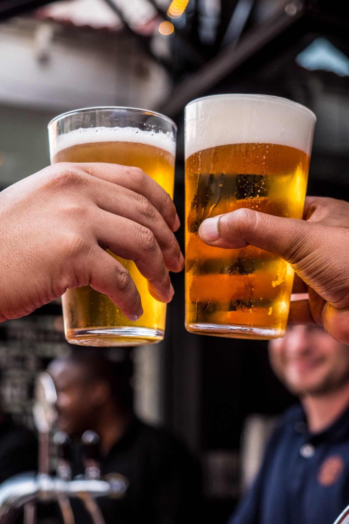 dos sosteniendo vasos de cerveza