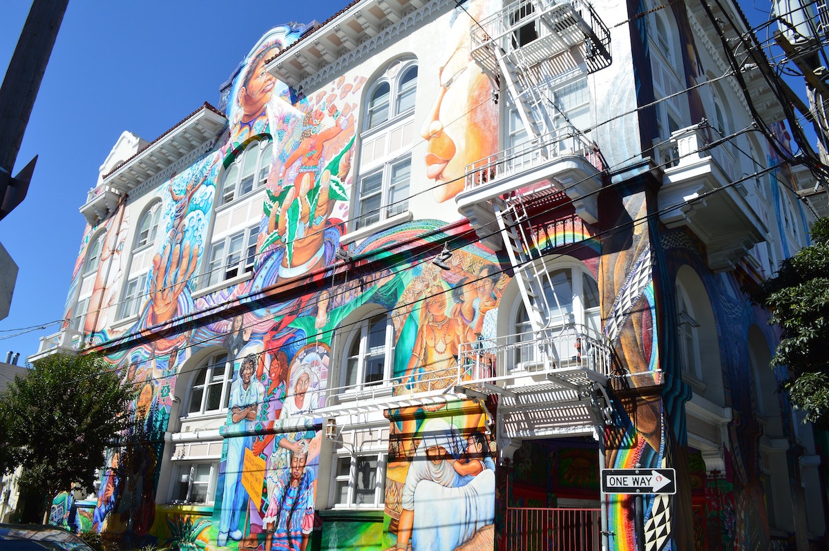 colorido mural de mujeres y niñas en un edificio blanco