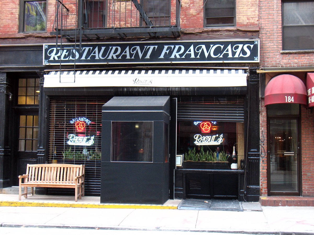Fuera del restaurante Raoul's en SoHo, Nueva York, con un gran cartel en blanco y negro que dice Restaurante francés