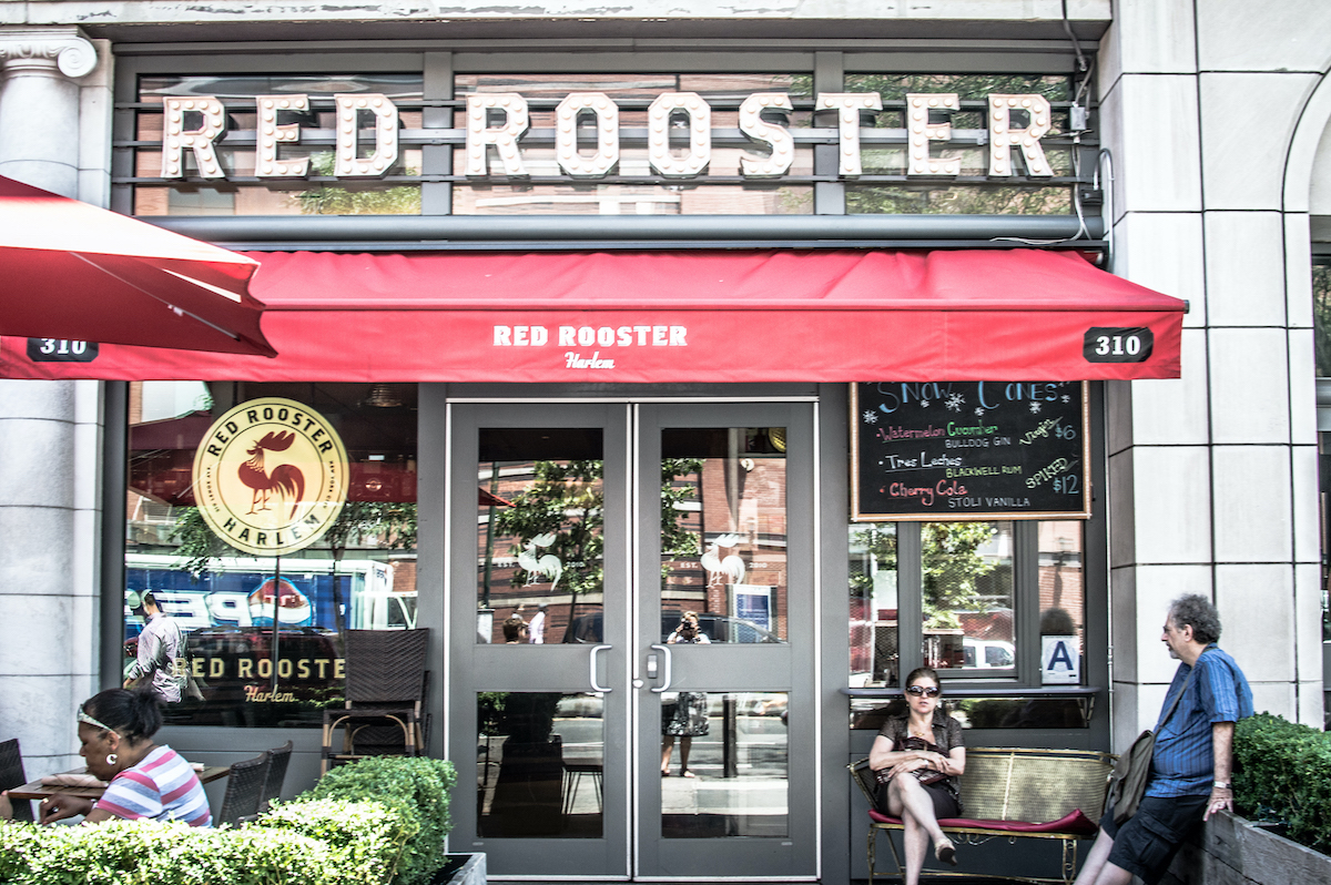 Exterior del restaurante Red Rooster en Harlem, NYC con una silueta roja sobre la puerta
