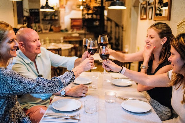 Un grupo de personas brindando con vino tinto en el restaurante Pla de la Garsa de Barcelona