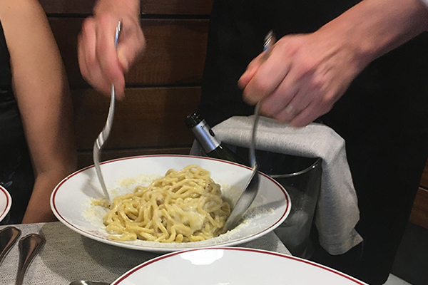 Pasta con cacio e pepe mezclada en la mesa de uno de los restaurantes de la Ciudad del Vaticano.