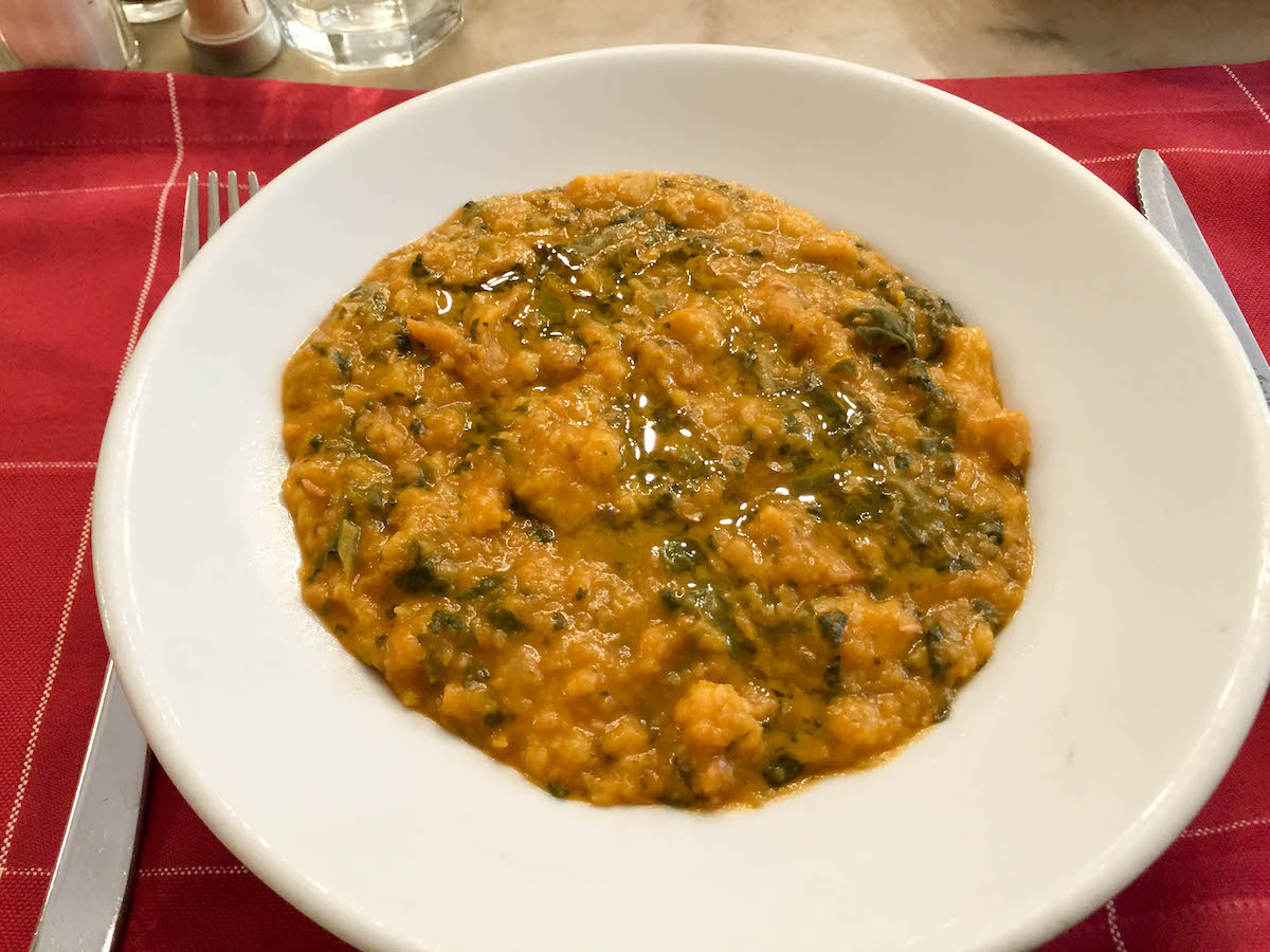 Pan toscano y sopa de col rizada en un tazón blanco