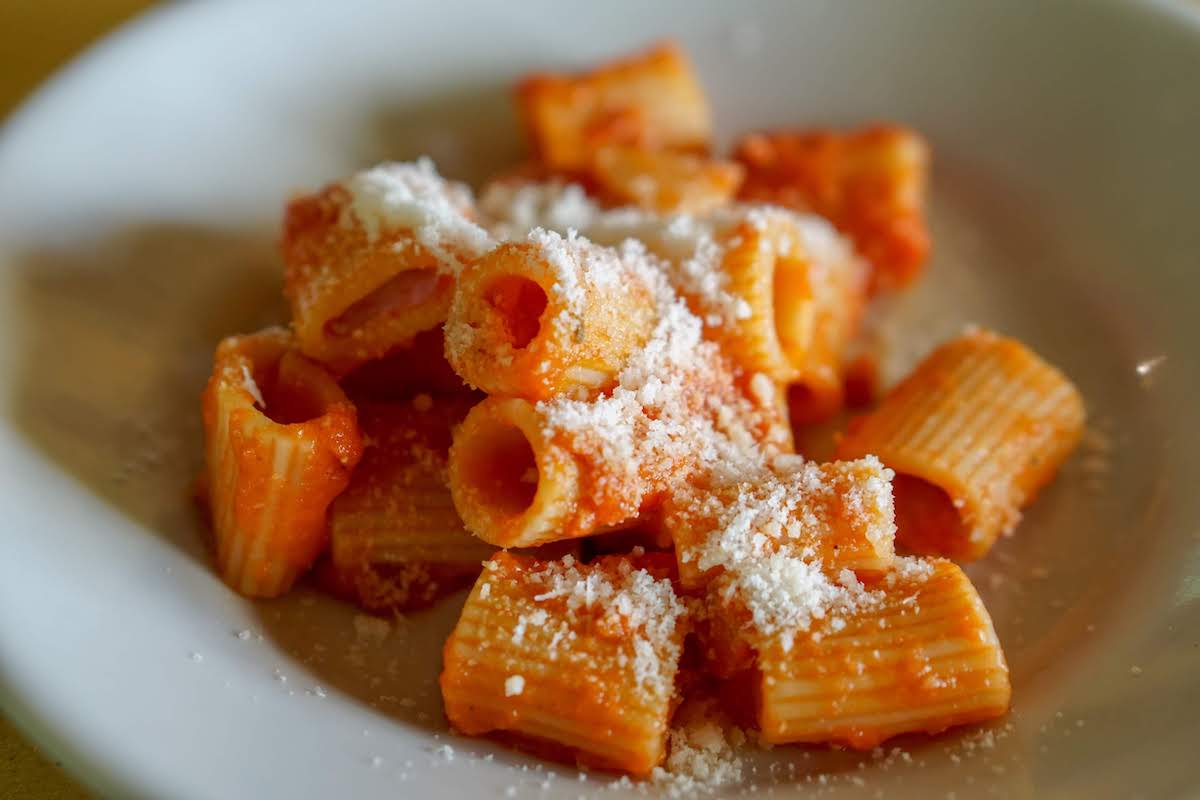Pasta rigatoni en salsa de tomate cubierta con queso rallado