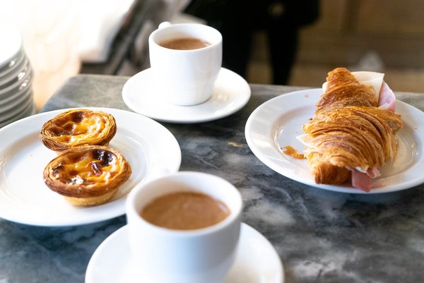 Tartas de crema pastelera, sándwich de croissant y café en la Confeitaria Nacional de Lisboa