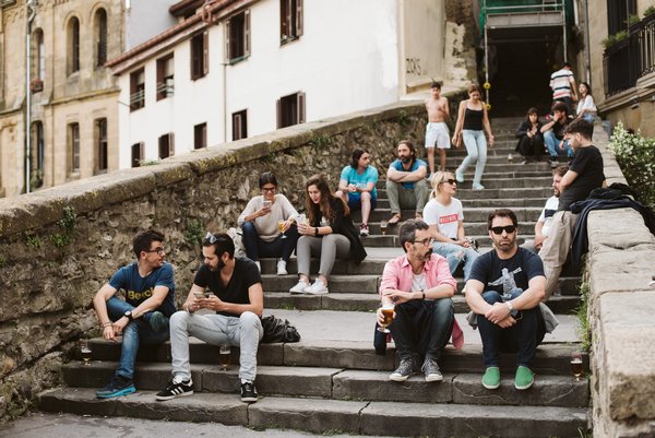 Personas sentadas en unos escalones en San Sebastián