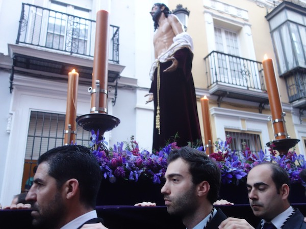 Hombres que llevan una carroza de Semana Santa en Sevilla, España.