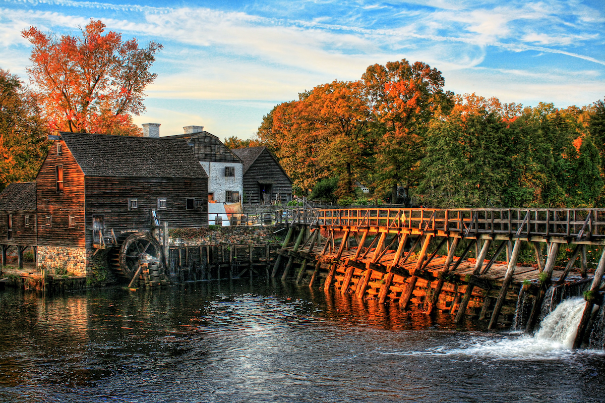Una casa de troncos del siglo XVIII y un puente de troncos en un día de otoño
