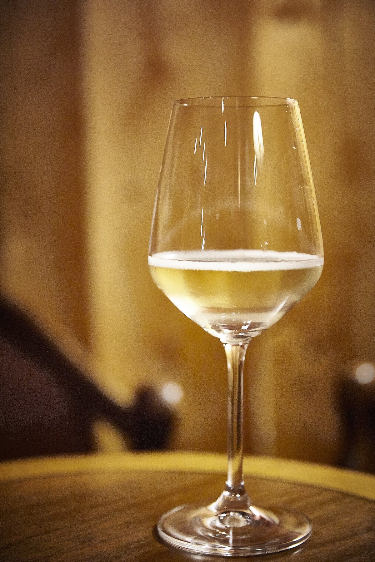 Copa de vino espumoso en mesa de madera