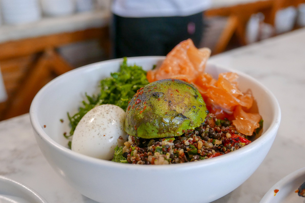 Tazón de quinoa y lentejas con huevo, col rizada, salmón y aguacate