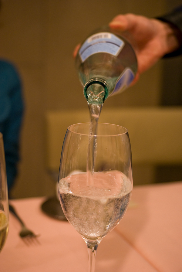 Vierta una botella de agua con gas en un vaso