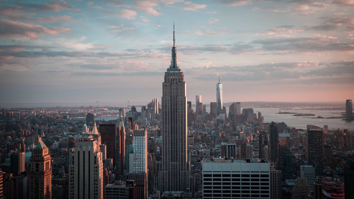 Una vista del horizonte de Nueva York al anochecer desde el Top of the Rock, con el Empire State Building prominentemente visible en primer plano.