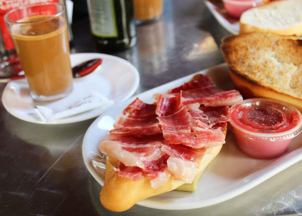 Desayuno típico en Sevilla: tostadas de jamón y tomate con café