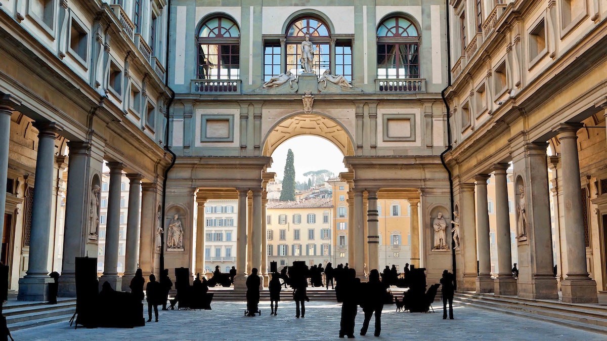 Entrada arqueada y gran plaza frente al Museo de los Uffizi en Florencia