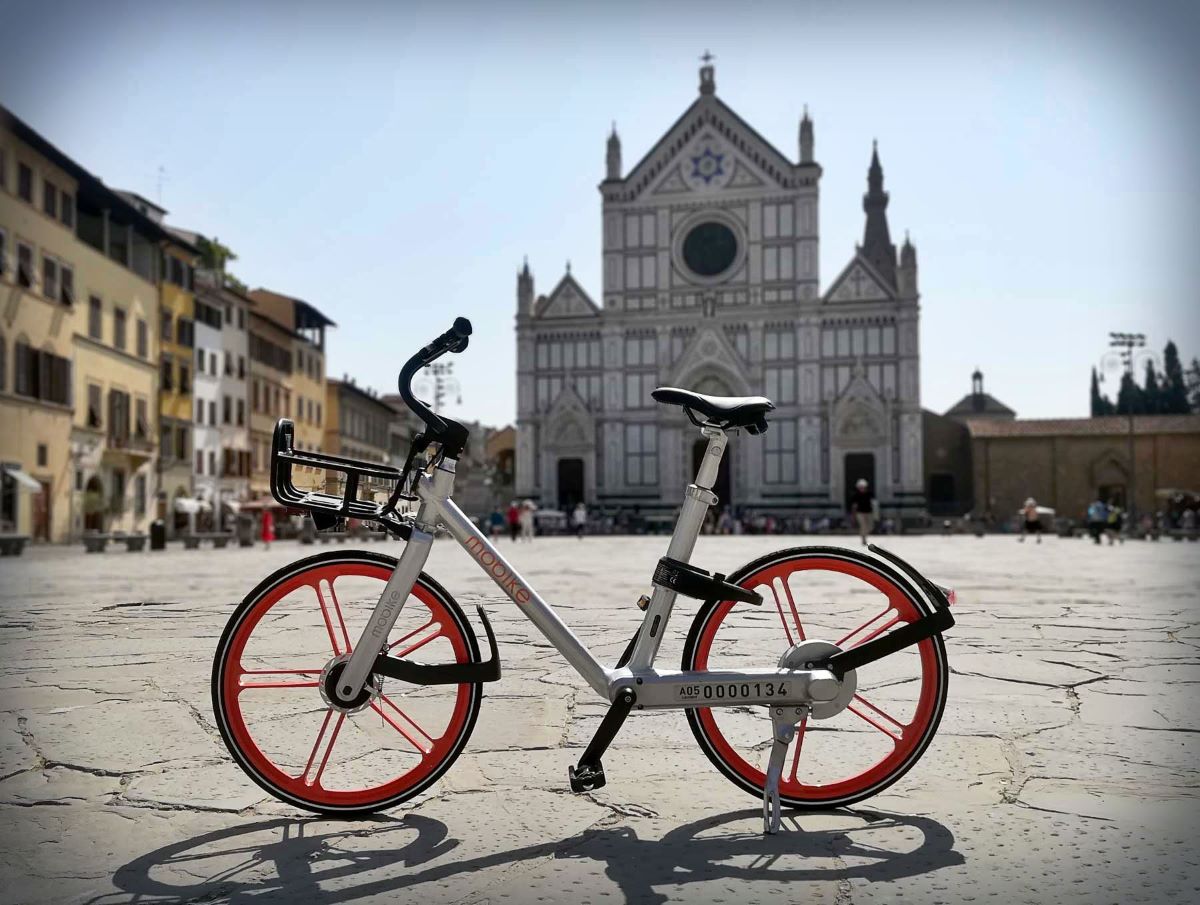bicicleta blanca en una placa con una iglesia antigua