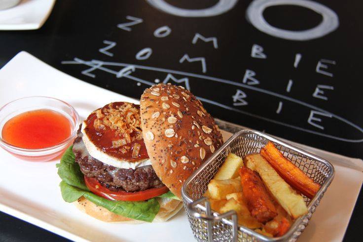 Esta hamburguesa de Zombie Bar está cubierta con queso de cabra caramelizado y cebolla frita crujiente, ¡lo que la convierte en una de las mejores hamburguesas de Madrid!